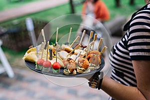 Waitress in holding a plate with canapes.