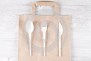 Catering and street fast food plastic fork, spoon, knife on paper bag.Eco-friendly food packaging and cotton eco bags on