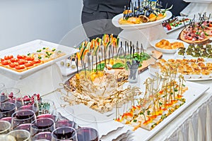 Catering table with food dishes, snacks and alcoholic and non-alcoholic drinks for guests of the event. Service at business meetin