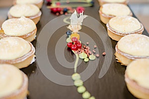 The catering wedding buffet. Wedding reception dessert table with delicious decorated white cupcakes with berries closeup