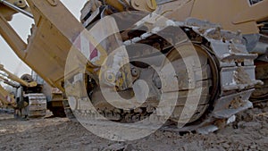 Caterpillar tracks close up shot. Close up view of tractor track wheels spinning and moving on ground
