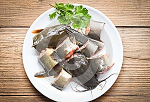 Catfish fillet on white plate, fresh raw catfish menu freshwater fish, catfish for cooking food, fish chopped with ingredients