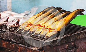 Catfish is grilled on skewers over coals
