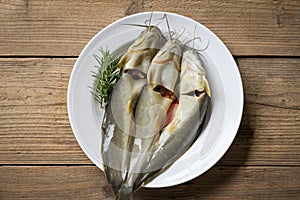 Catfish on plate, fresh raw catfish freshwater fish, catfish for cooking food, fish with ingredients herb rosemary on wooden