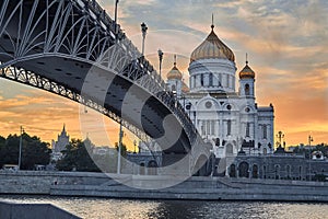 Cathedral Of Christ The Saviour in Moscow in orange sunset light. Patriarch bridge. The bridge leads to the temple.