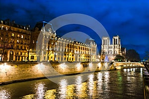 Cathedral Notre Dame de Paris at night by the river Seine