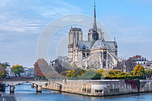 Cathedral of Notre Dame de Paris sunny autumn afternoon. Embankment of the Seine River. The natives and tourists take a walk and