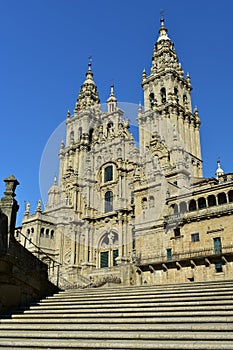Cathedral: Side view from stairs. Baroque facade, Obradoiro, clean stone, blue sky. Santiago de Compostela, Spain. photo
