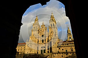 Cathedral with sunset light, view from Town Hall arch. Obradoiro Square, rainy day, grey sky. Baroque facade and towers, Santiago photo