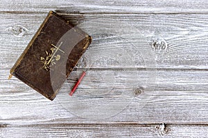 Catholic bible and red church nonflammable candle on wooden background with copy space