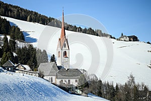 Catholic church in the Italian dolomites in wintertime with snow.