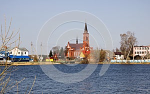 Catholic church of red brick on the river bank