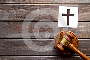 Catholic cross - catholicism religion concept - near gavel on wooden background top view. Religious conflict concept