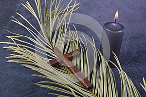 Catholic Cross with palm leaf and burning candle. Ash Wednesday, Lent season, Holy Week, Good Friday and Palm Sunday concept.