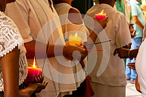 Catholic faithful holding lit candles inside the Campo Santo church in the city of Salvador, Bahia