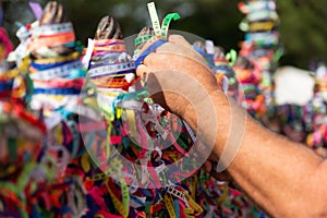 A Catholic faithful is seen tying a souvenir ribbon on the railing of the Senhor do Bonfim church in the city of Salvador, Bahia