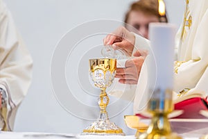Catholic Holy Mass - golden chalice with wine on the altar