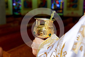 catholic priest with chalice cup during consecration ceremony