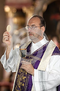 Catholic priest during communion in worship photo