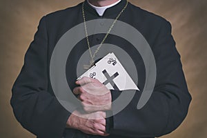 Catholic priest holds the holy bible