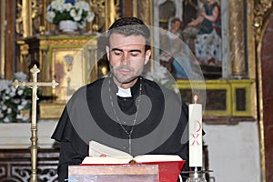 Catholic priest reading the Bible