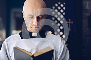 Catholic priest reading bible in church