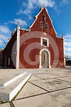 Catholic red colonial church Itzimna in a park, Merida, Yucatan, Mexico photo