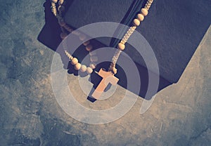 Catholic rosary beads with old book on cement table prayer, rosa