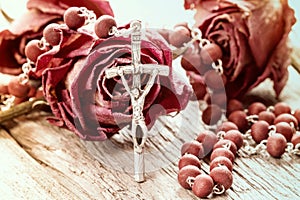 Catholic rosary and dry roses photo