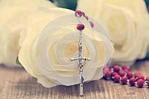 Catholic rosary and white roses photo