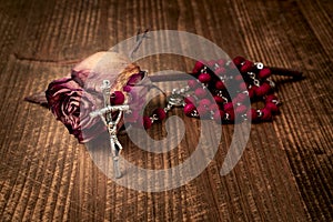 Catholic rosary and wilted rose