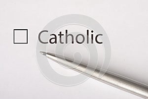 Catolic - checkbox with a tick on white paper with metal pen. Checklist concept