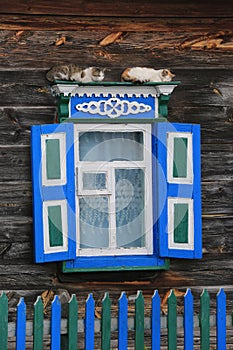 Cats on window of old wooden rural house house