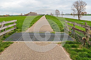 Cattle grid in a narrow cycle and walking path along a river in the Netherlands