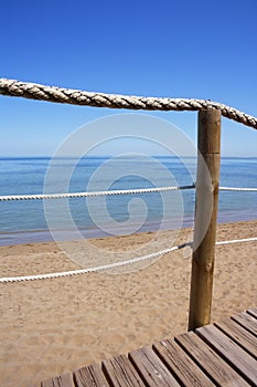 Catwalk on wood rope railing on sea beach