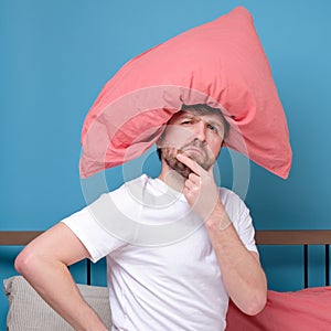 Cauacsian young man with pillow on head lying in bed and screaming being alone stressed because of quarantine