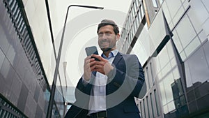 Caucasian 40s business man happy smiling excited positive read good news sms message businessman male entrepreneur
