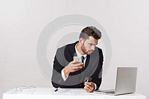 Caucasian attractive businessman worried and tired talking on mobile phone sitting at office desk working in stress