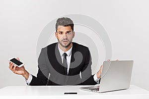 Caucasian attractive businessman worried and tired talking on mobile phone sitting at office desk working in stress