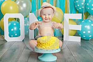 Caucasian baby boy celebrating his first birthday. Cake smash