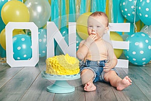 Caucasian baby boy celebrating his first birthday. Cake smash