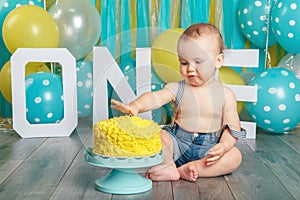 Caucasian baby boy celebrating his first birthday. Cake smash