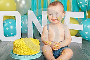 Caucasian baby boy celebrating his first birthday. Cake smash