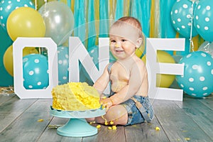 Caucasian baby boy celebrating his first birthday. Cake smash