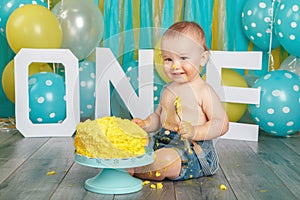 Caucasian baby boy celebrating his first birthday. Cake smash