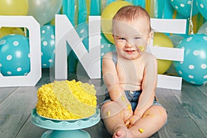 Caucasian baby boy celebrating his first birthday. Cake smash