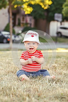 Caucasian baby boy wearing Canadian hat with maple leaf