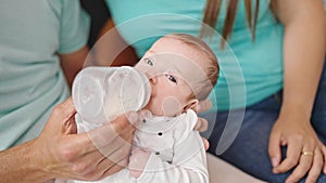 Caucasian baby girl drinking milk from feeding bottle