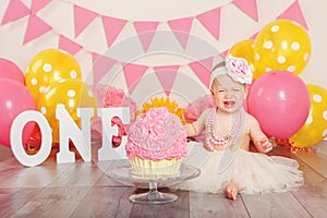 Caucasian baby girl in tutu tulle skirt celebrating her first birthday. Cake smash concept