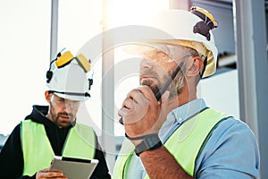 Caucasian bearded engineer with walkie-talkie control working process on construction site. Team of structural engineers working